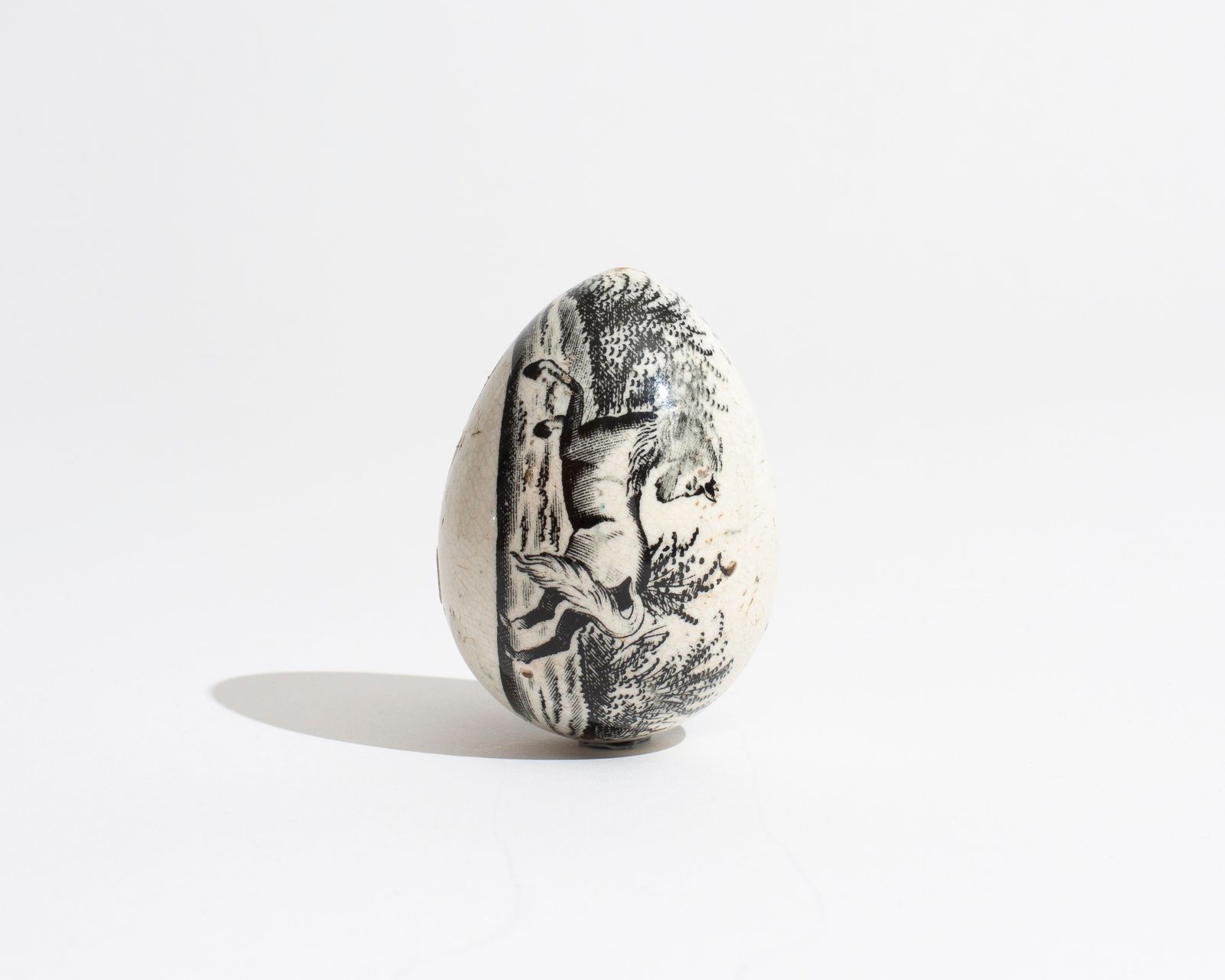 19TH CENTURY TRANSFER DECORATED POTTERY DARNING EGG IN BLACK WITH HORSE MOTIF [1830]