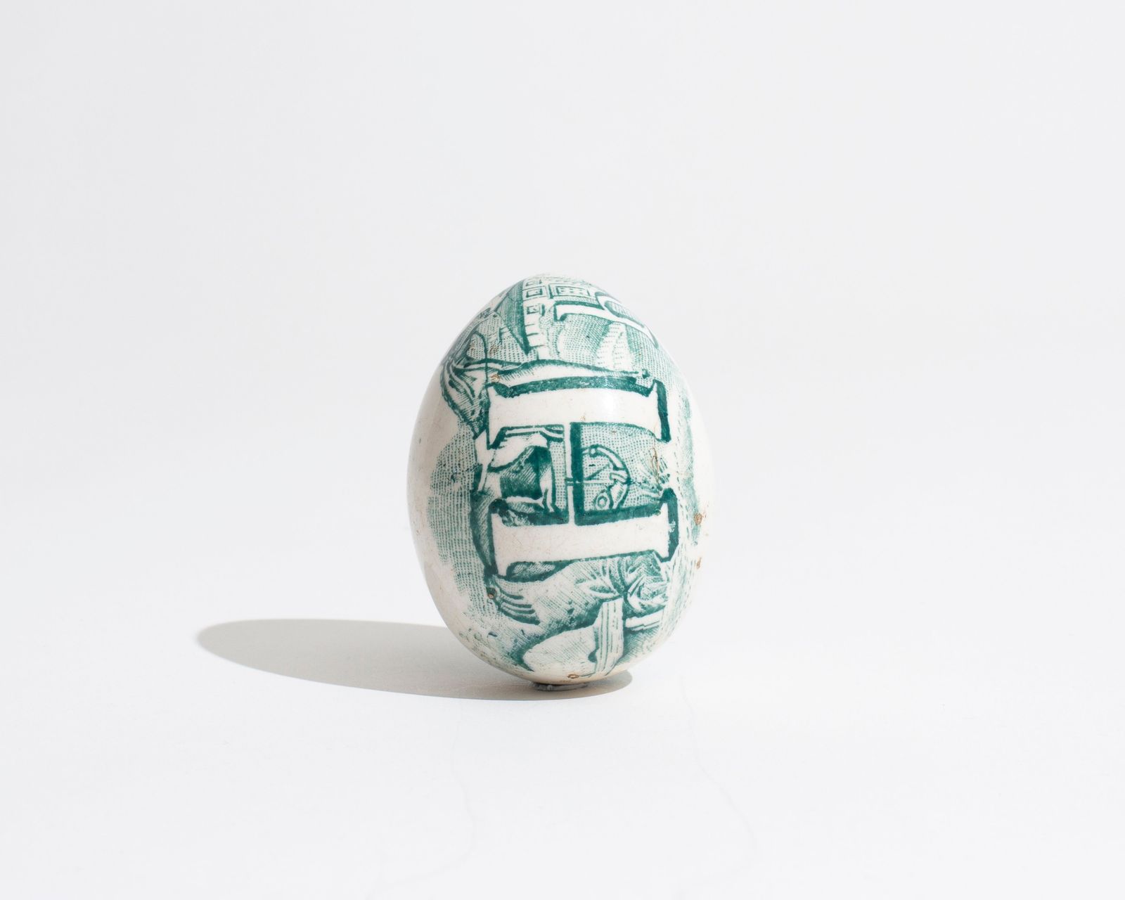 19TH CENTURY TRANSFER DECORATED POTTERY DARNING EGG IN GREEN WITH HAND-PAINTED 'H' MOTIF [1830]